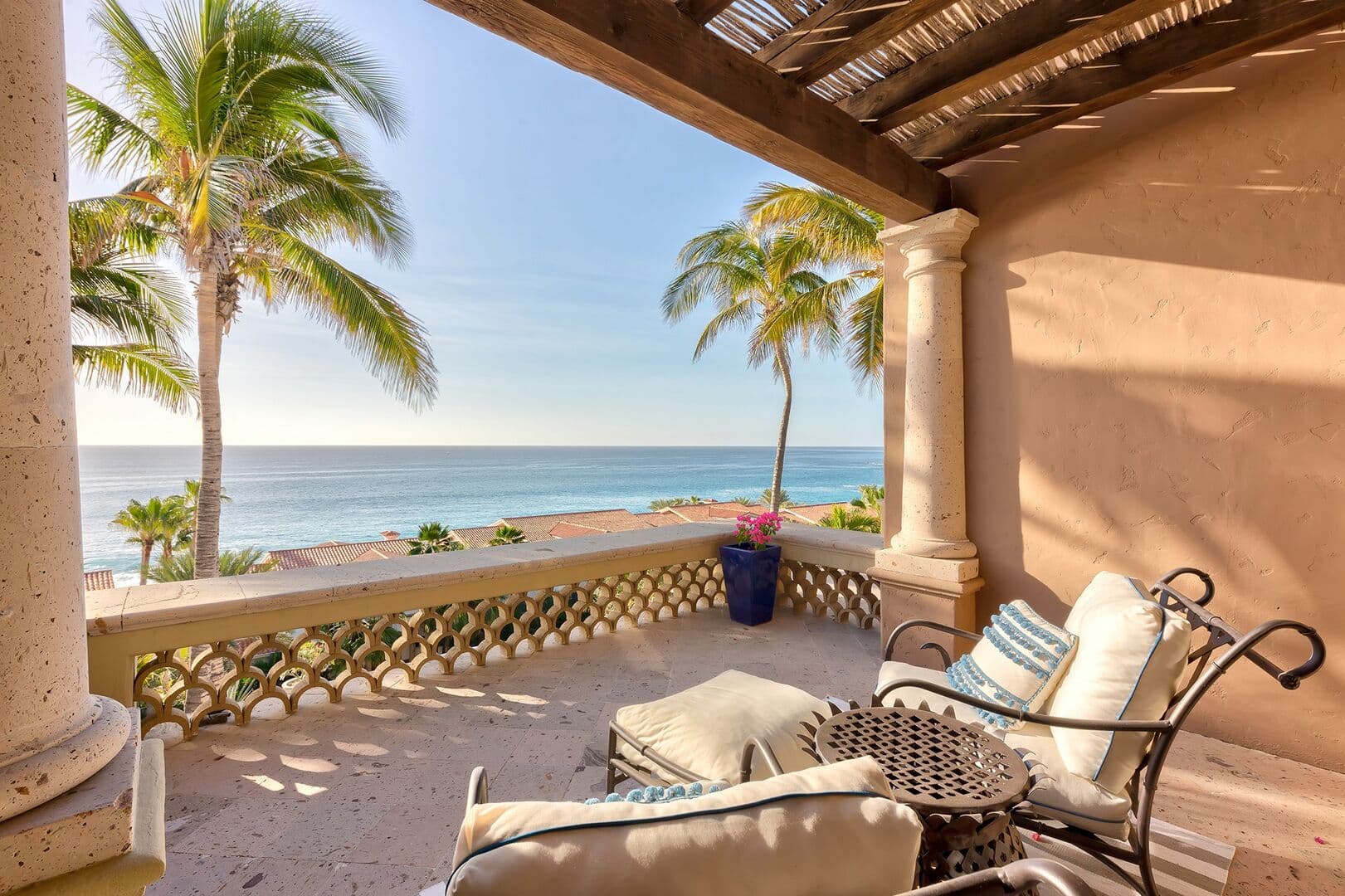 View of the ocean and palm trees from the seating area on the second story balcony.
