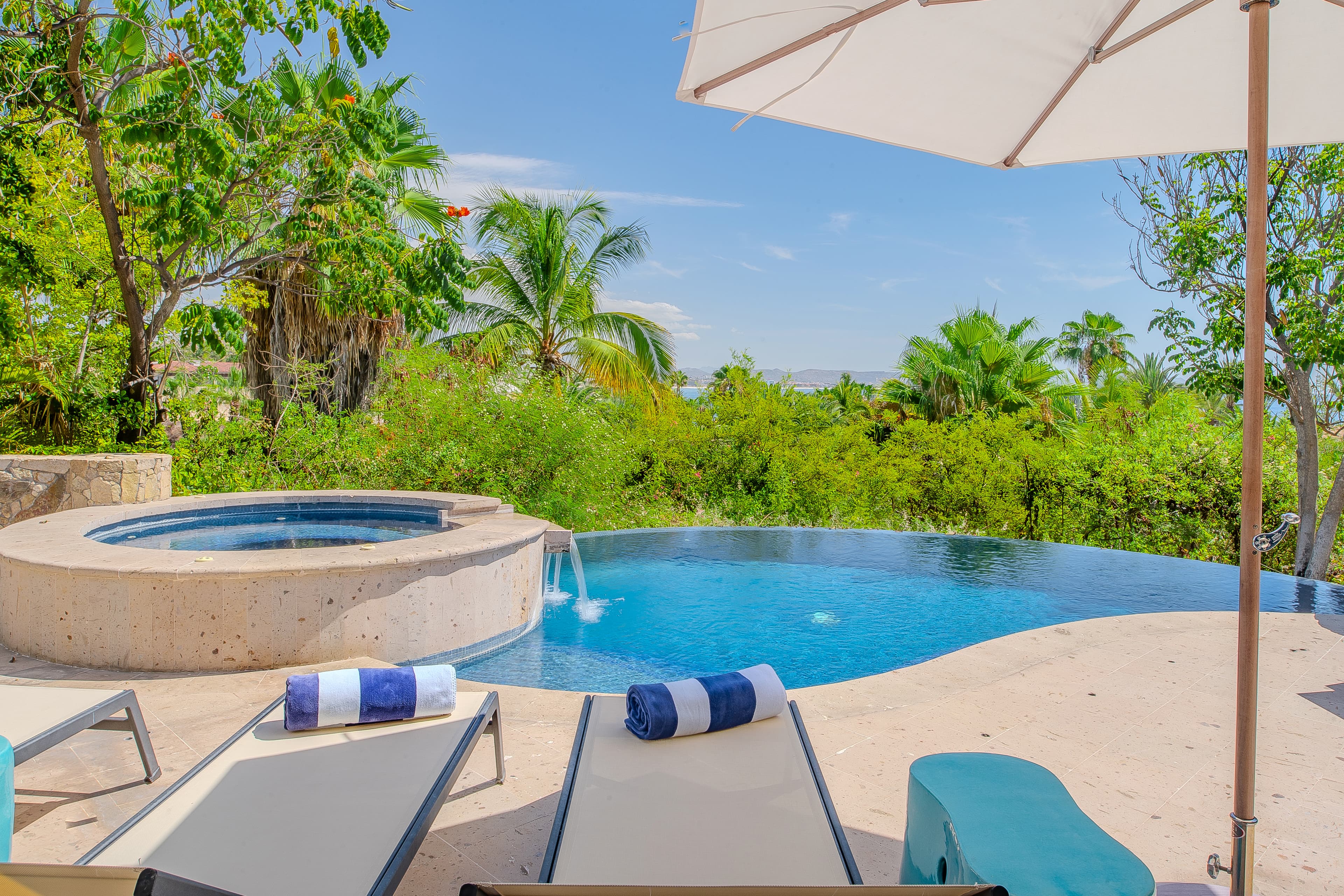 Soak in your private infinity pool overlooking lush tropical gardens, with a built-in hot tub and shaded loungers waiting for you to unwind in paradise.
