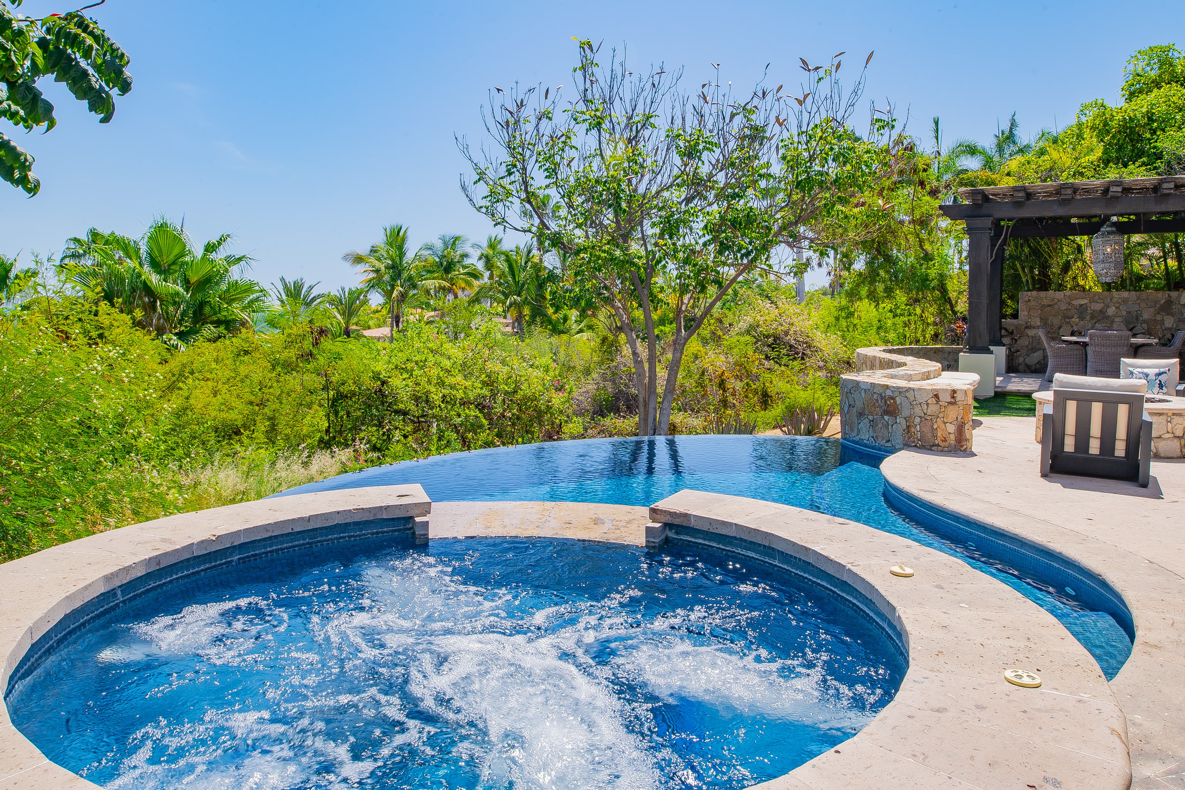 Soak in your private hot tub with views of lush tropical gardens and the infinity pool, then lounge in the shaded patio seating for pure relaxation.