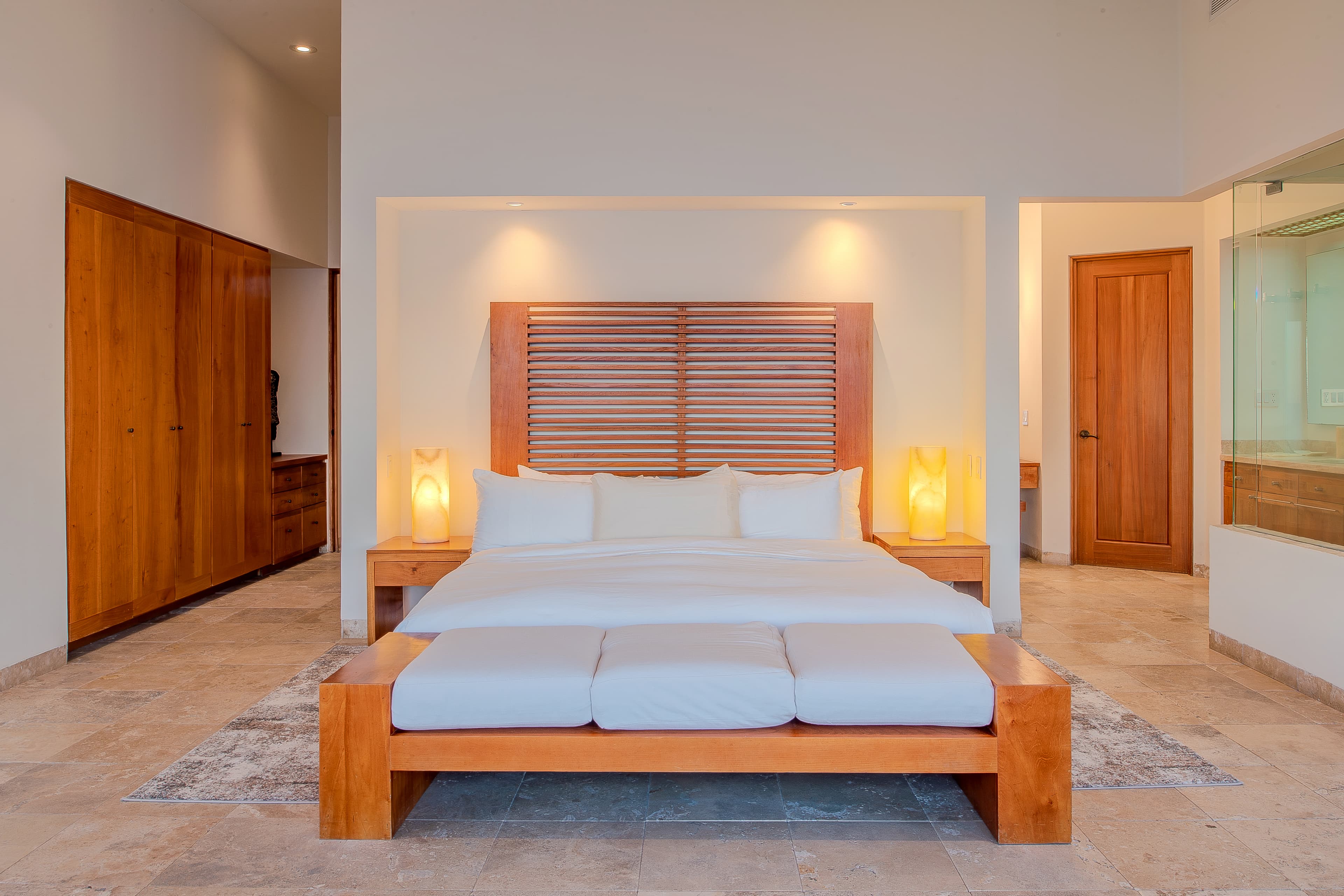 Bedroom 1 · Sink into your plush king bed framed by warm wood accents and ambient lighting, creating a serene sanctuary for restful nights. The spacious layout and soft tones invite you to unwind completely.
