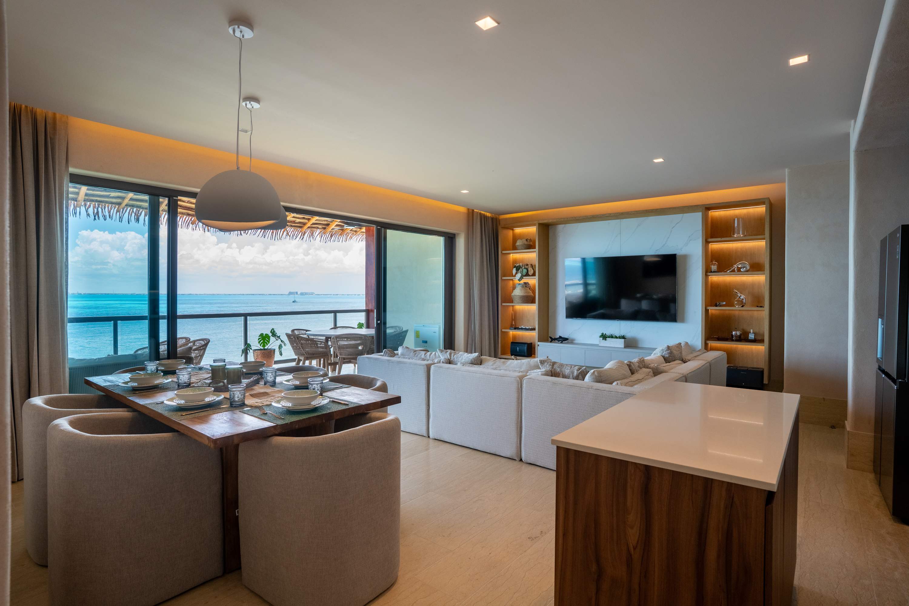 A modern living and dining room with a stunning ocean view.